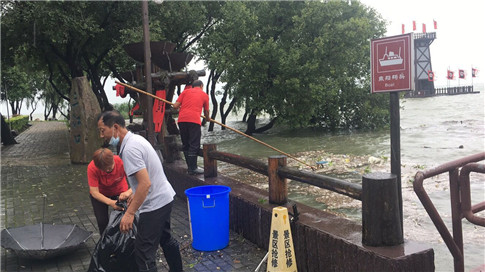 冒雨打捞沿湖漂浮物.jpg